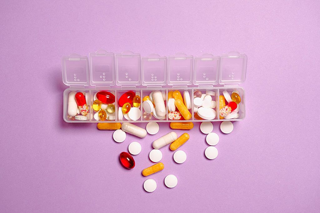 medicamentos regados encima de una mesa rosada